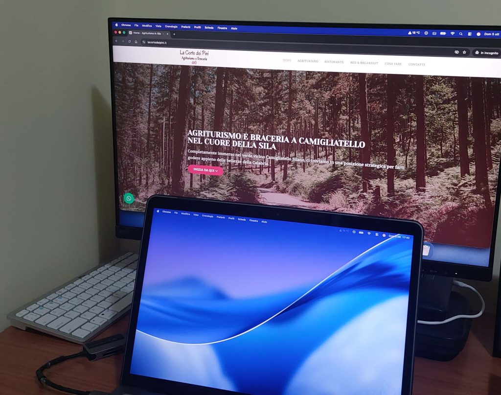 Notebook collegato ad un monitor che mostra il sito La Corte dei Pini