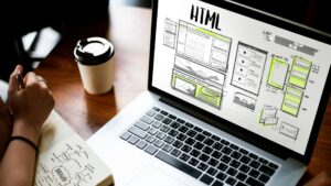 Avere un sito web nel 2026: l'immagine mostra un PC su un scrivania, con una persona che prende appunti su un taccuino
